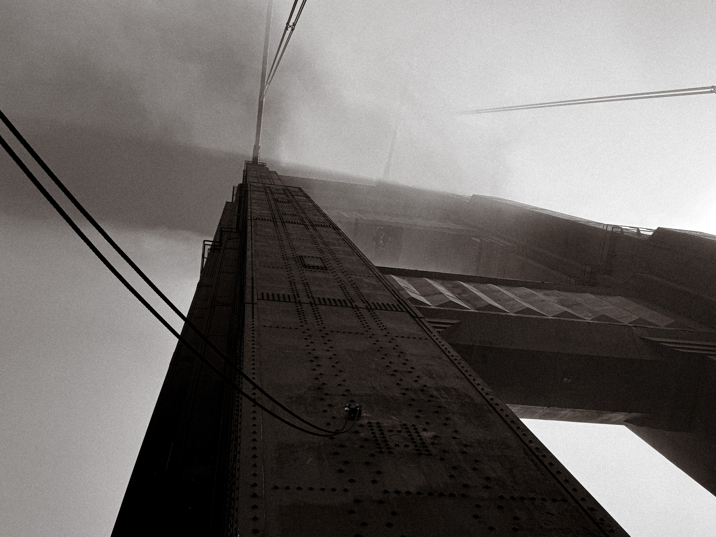 Suspension bridge structure disappearing into fog